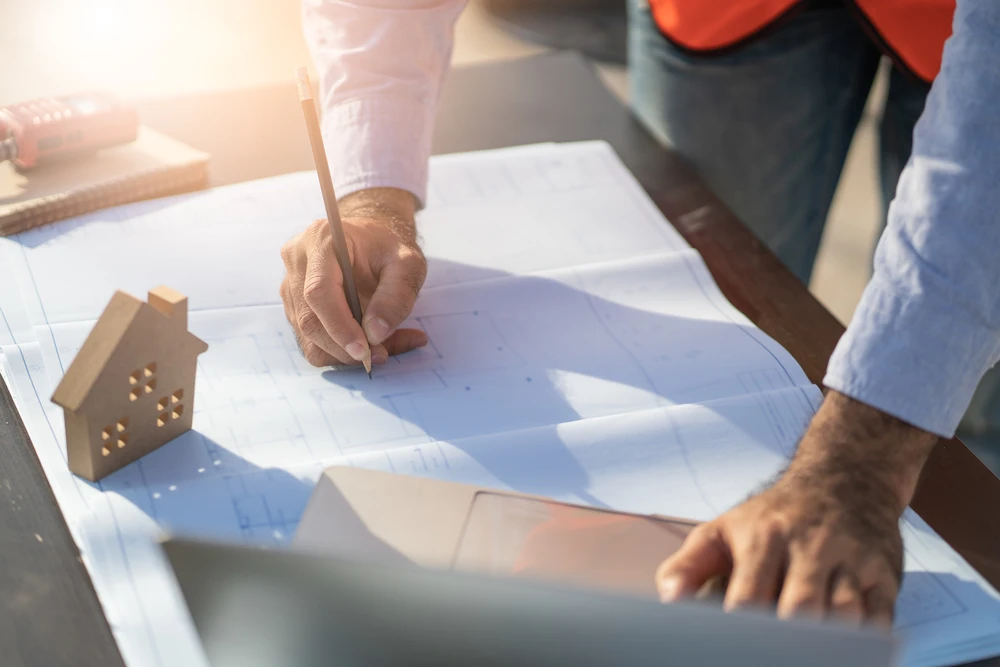 Architecte ou ingénieur travaillant sur plans techniques sur table de travail